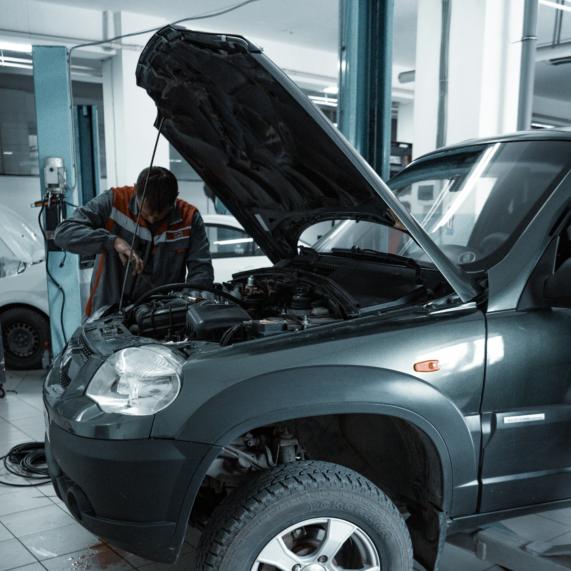 Automotive technician working on a vehicle in a professional service bay